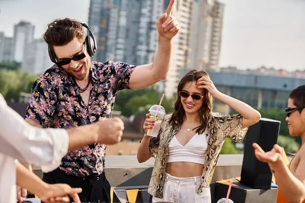 Séduisante femme joyeuse avec cocktail dansant à la main au DJ set à côté de ses amis à la fête sur le toit — Photo de stock