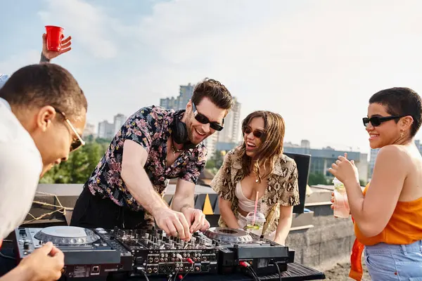Amigos multiculturais alegres com óculos de sol elegantes festejando no telhado ao lado de equipamentos de DJ — Fotografia de Stock