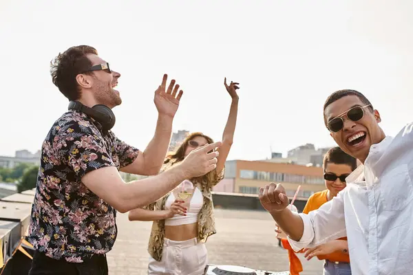 Радісні мультикультурні друзі зі стильними сонцезахисними окулярами, що вечірки на ді-джеї, встановлені на даху разом — стокове фото