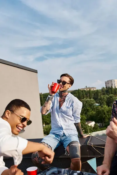 Amigos alegres multirraciales con gafas de sol de moda que se divierten en la fiesta en la azotea bailando para DJ conjunto - foto de stock