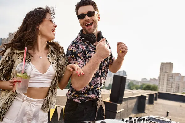 Joyeuse femme attrayante avec cocktail dansant avec beau DJ joyeux à la musique à la fête sur le toit — Photo de stock