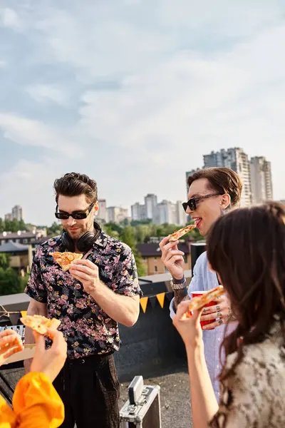 Alegres amigos bonitos em trajes vívidos casuais comer pizza e desfrutar de bebidas na festa — Fotografia de Stock
