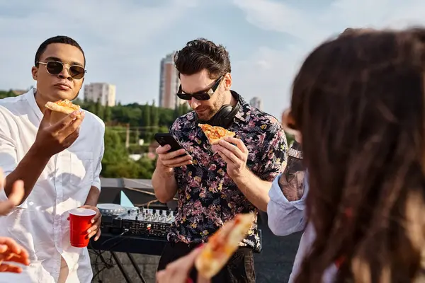 Gente alegre multicultural con gafas de sol de moda comiendo pizza y bebiendo cócteles en la fiesta - foto de stock