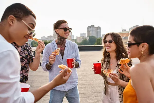 Мультикультурні веселі люди з модними сонцезахисними окулярами їдять піцу та коктейлі на вечірці — стокове фото