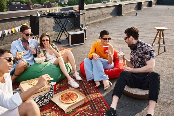 Amigos multiculturais alegres em trajes vibrantes com óculos de sol desfrutando de pizza e bebidas na festa — Fotografia de Stock
