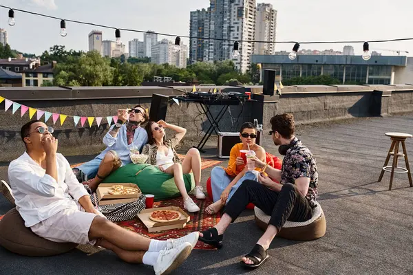 Joyous multicultural friends in vibrant attires with sunglasses enjoying pizza and drinks at party — Stock Photo