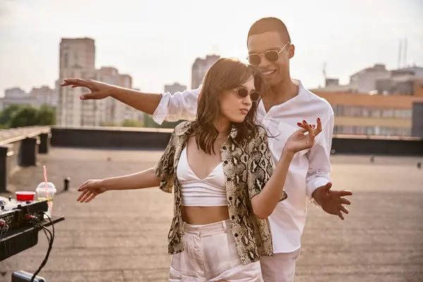 Handsome joyful african american man dancing actively with his beautiful friend at rooftop party — Stock Photo