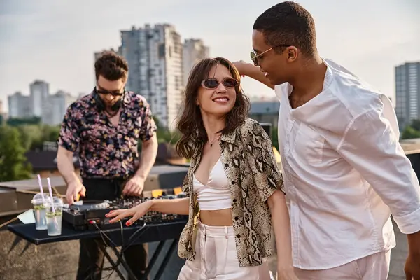 Handsome jolly african american man dancing with his beautiful friend at rooftop party next to DJ — Stock Photo