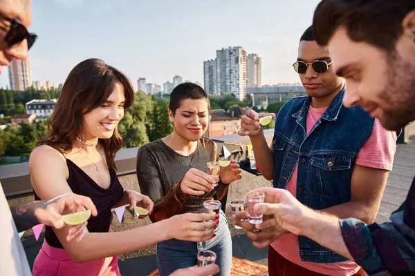 Fröhliche multirassische Freunde mit stylischer Sonnenbrille, die auf einer Party Tequila mit Limette und Salz trinken — Stockfoto