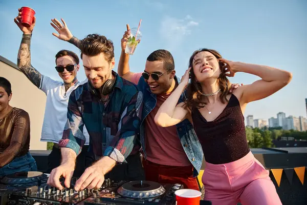 Jolly multicultural people in vivid outfits partying together next to attractive DJ at rooftop party — Stock Photo