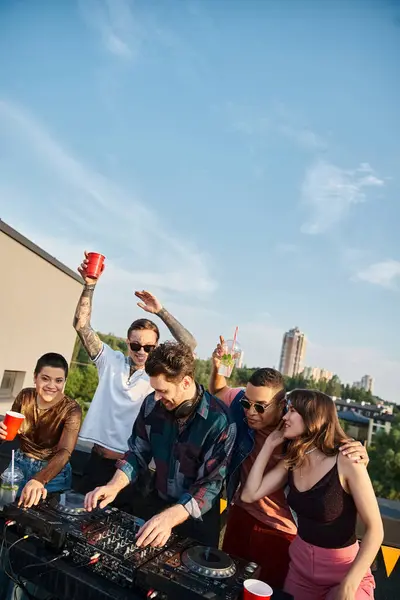 Cheerful good looking diverse friends in urban attires partying together with handsome DJ at party — Stock Photo