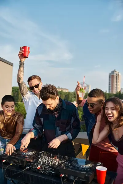 Diverse cheerful people in vivid outfits partying together next to handsome DJ at rooftop party — Stock Photo