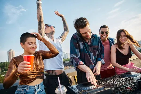 Group of jolly multicultural friends drinking cocktails and partying together at rooftop party — Stock Photo