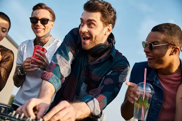 Group of joyous multiracial friends drinking cocktails and partying together at rooftop party — Stock Photo