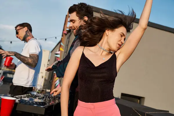 Focus on joyous long haired woman in vivid attire partying next to her jolly blurred friends — Stock Photo