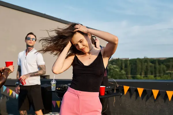 Focus on jolly long haired woman in vibrant attire partying next to her jolly blurred friends — Stock Photo
