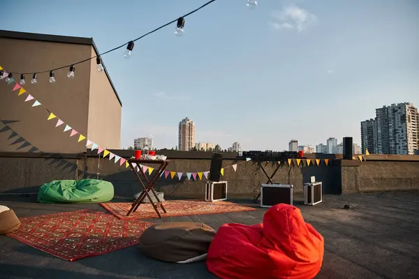 Objet photo de toit extérieur avec tapis rouges et équipement DJ avec assiettes et tasses sur la table — Photo de stock