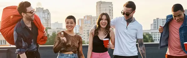 Happy diverse friends in urban clothes with drinks and bean bag chair at rooftop party, banner — Stock Photo