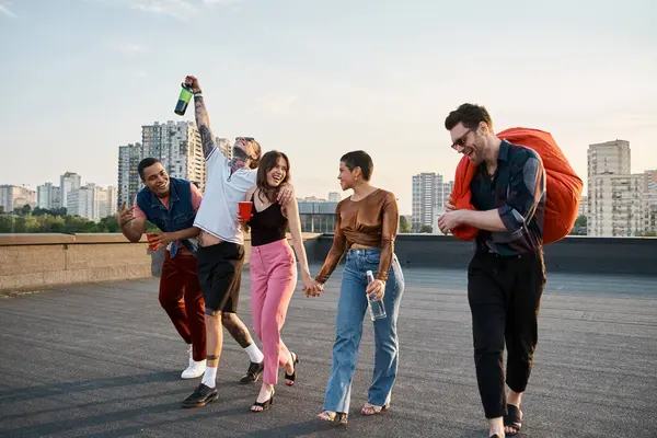 Joyous multiracial friends with different drinks and bean bag chair in hands at rooftop party — Stock Photo