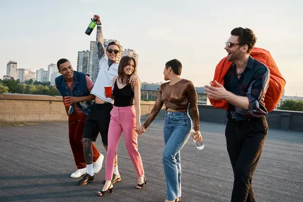 Merry interracial friends in urban clothes with different drinks and bean bag chair at rooftop party — Stock Photo