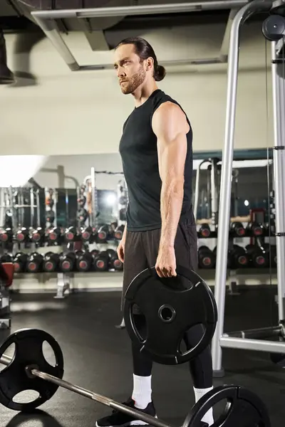 Athletischer Mann im Fitnessstudio mit einer Langhantel, der während der Trainingseinheit Stärke und Entschlossenheit zeigt. — Stockfoto