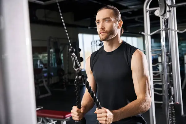 Un atlético en uso activo sostiene una cuerda en un gimnasio, mostrando poder y determinación en su entrenamiento. - foto de stock