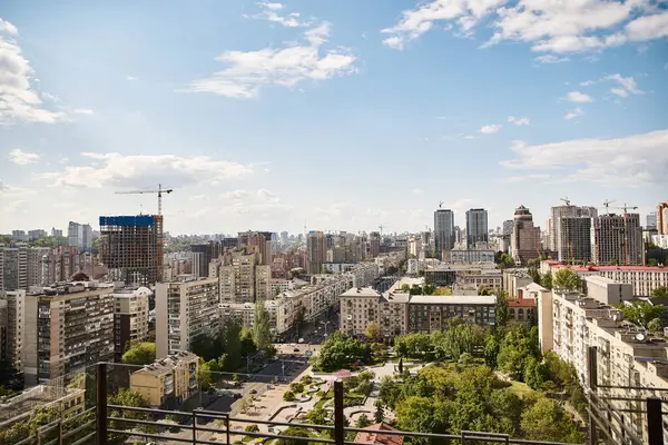 Una pintoresca ciudad se extiende por debajo, vista desde un edificio alto, mostrando rascacielos, calles bulliciosas y vibrante vida en la ciudad - foto de stock