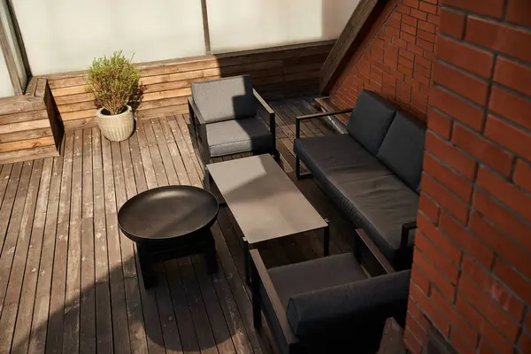 Stilvolle Anordnung von Sofa und Stühlen auf poliertem Holzboden, die eine warme und einladende Atmosphäre in einem Raum schafft — Stockfoto