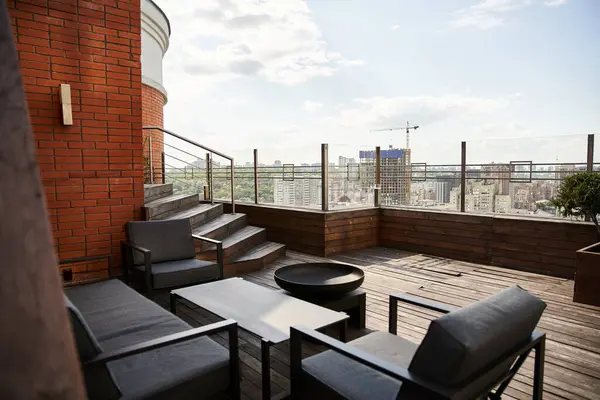 Un acogedor balcón con dos sillas y una mesa, con vistas a un bullicioso paisaje urbano debajo - foto de stock