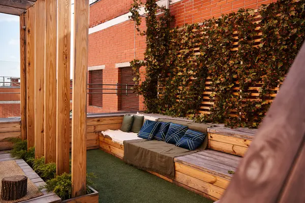 Un acogedor sofá situado en una terraza de madera rodeada de naturaleza, que ofrece un lugar tranquilo y relajante para relajarse al aire libre - foto de stock