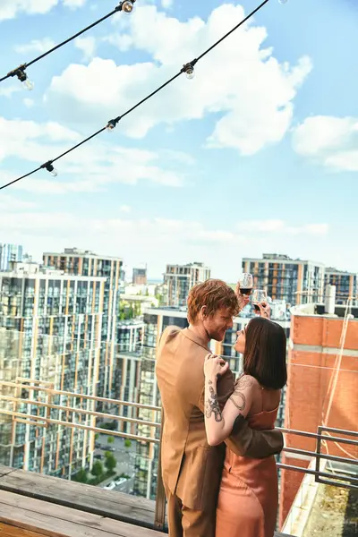 Ein Mann und eine Frau stehen auf einem Balkon mit Blick auf das Stadtbild, verloren in einem romantischen Moment, während sie der Musik der Nacht lauschen — Stockfoto