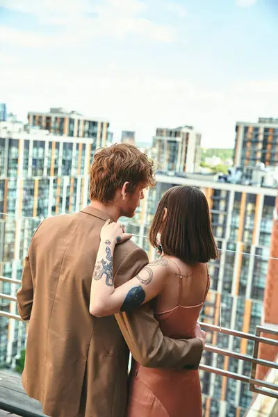 A man and a woman standing together on a balcony, enjoying the view and each others company on a peaceful afternoon — Stock Photo