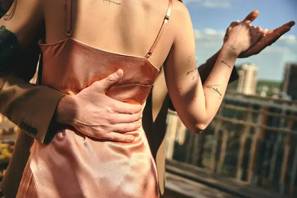 A calm woman in an elegant pink dress gently supporting her stomach with a serene expression on her face — Stock Photo