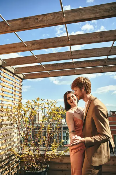 Ein Mann und eine Frau stehen auf einem Dach und blicken auf die Skyline der Stadt — Stockfoto