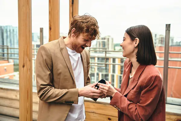 A couple shares a laugh as she presents an engagement ring, their happiness aglow with twilight. — Stock Photo