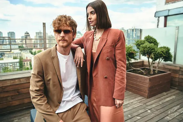 Um homem elegante e uma mulher na moda marcando uma pose confiante juntos, exalando elegância e carisma — Fotografia de Stock