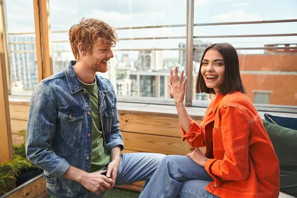 Two friends enjoying a lighthearted conversation on an urban rooftop garden, basking in the warmth of a cheerful day — Stock Photo