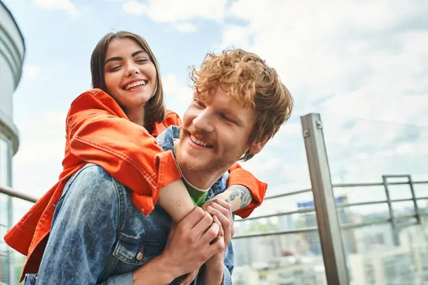 A man gracefully carries a woman on his back, showcasing strength and trust in a joyful moment — Stock Photo