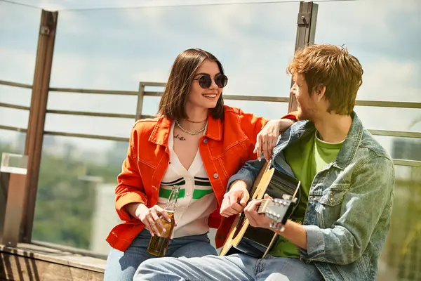 A man sits next to a woman, who is holding a guitar. They appear engaged in a musical conversation, immersed in creating melodies together — Stock Photo