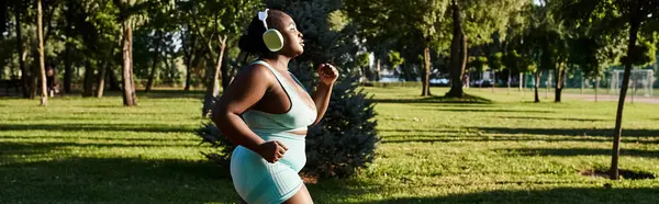 Une Afro-Américaine en tenue de sport, court gracieusement sur un terrain en plein air. — Photo de stock