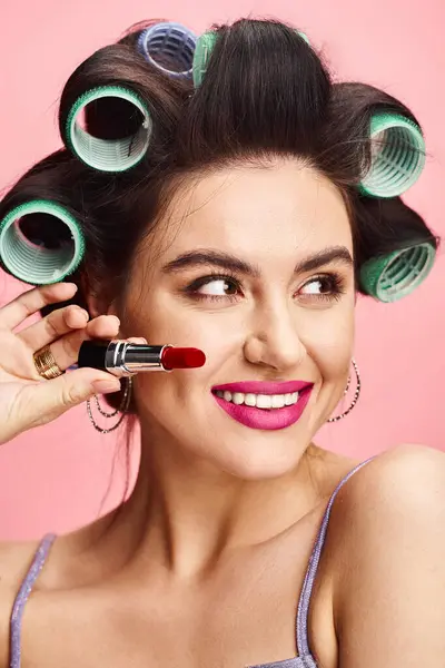 A vibrant woman with natural beauty wearing a bunch of curlers in her hair. — Stock Photo