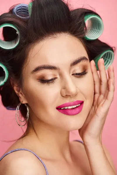 Woman with curlers in her hair, exuding natural beauty against vibrant backdrop. — Stock Photo
