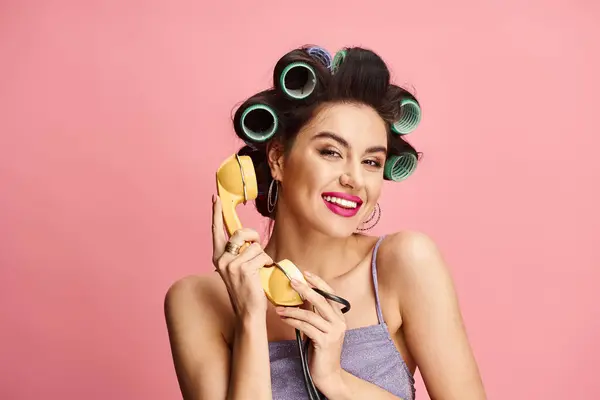 Mujer seductora graciosamente sosteniendo teléfono retro. - foto de stock