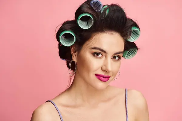 Una mujer con rulos en el pelo preparándose para un nuevo look. - foto de stock