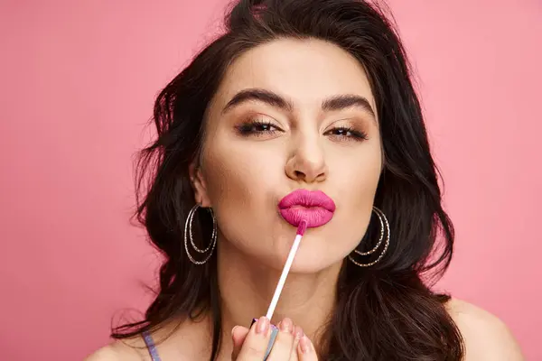 A stunning woman with long black hair and pink lips poses against a vibrant backdrop. — Stock Photo