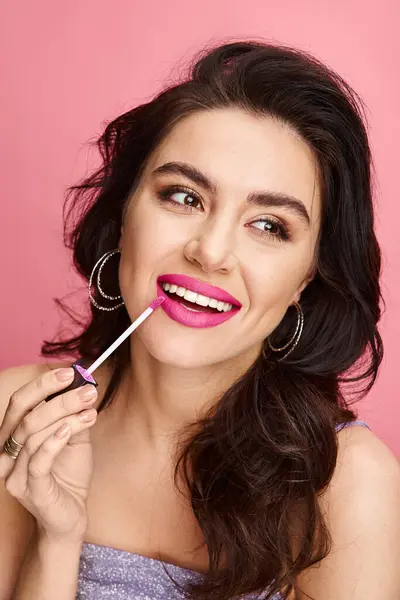 A beautiful woman with natural beauty showcases pink lipstick on her lips against a vibrant backdrop. — Stock Photo