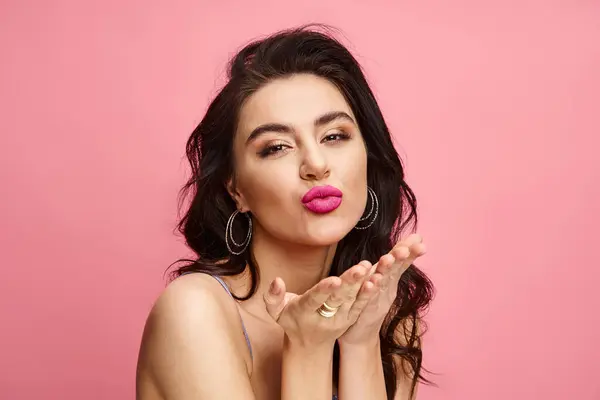 A captivating woman with long black hair and pink lipstick posing against a vibrant backdrop. — Stock Photo
