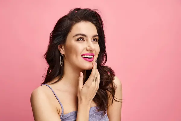 A captivating woman striking a pose against a vibrant pink background. — Stock Photo