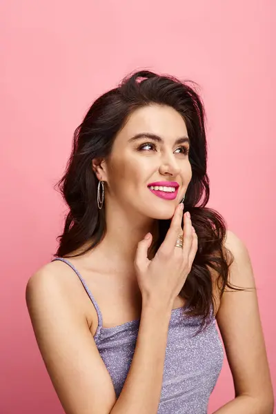 A beautiful woman striking a pose against a vibrant pink background. — Stock Photo