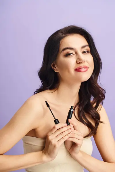 A woman applying makeup with a black mascara. — Stock Photo